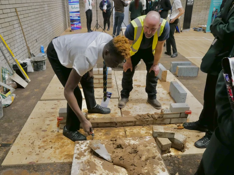 A Stride UK coach working with a young person in a sports hall
