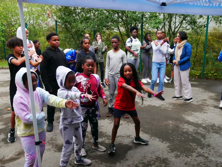 A group of children and Stride UK staff outdoors at a community sports hub